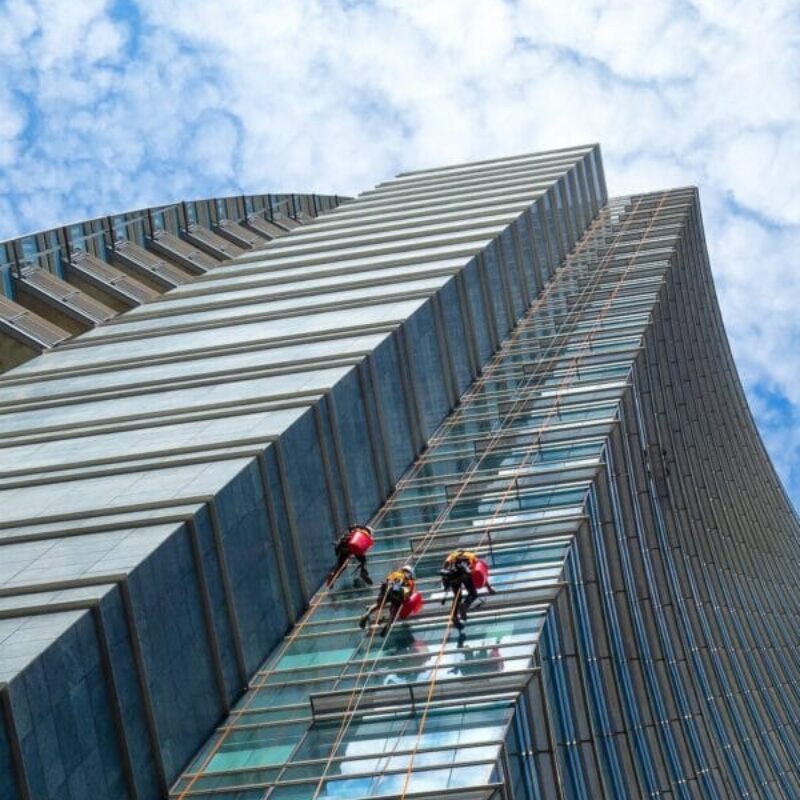 Group of Alpinists in service for windows cleaning of skyscraper