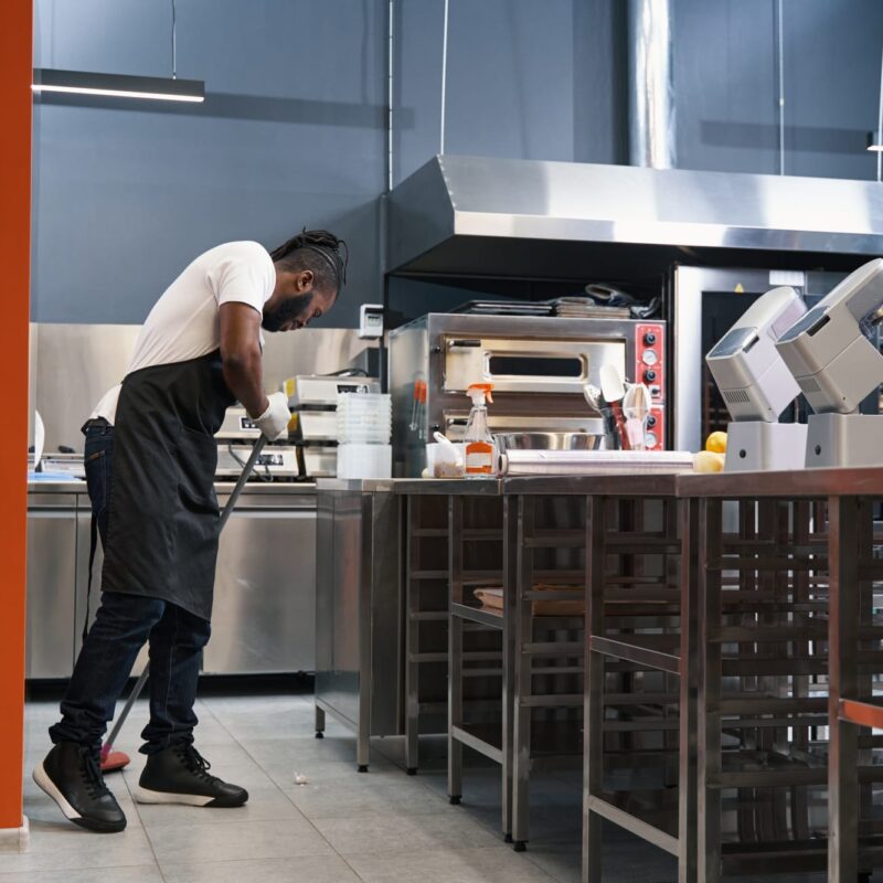 Adult chef cleaning work place in restaurant